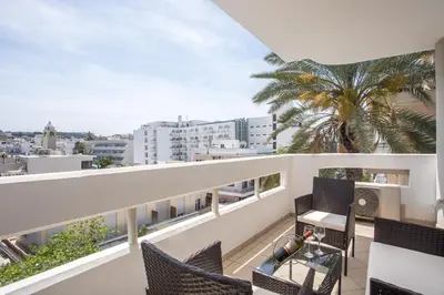 a balcony with chairs and a palm tree at DownTown Horizon View in Rhodes Town
