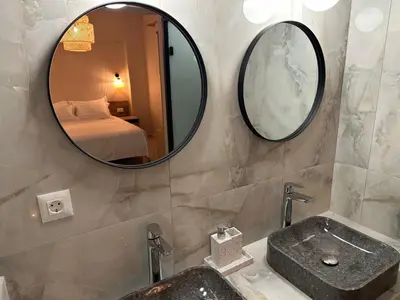 a bathroom with a sink and a mirror at Katalyma Vouno in Ialyssos