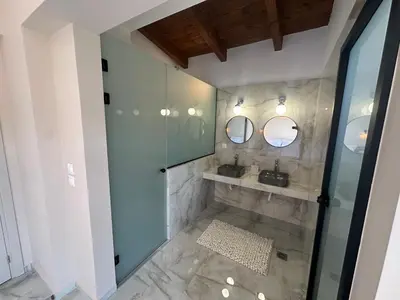 a bathroom with a sink and two mirrors at Katalyma Vouno in Ialyssos