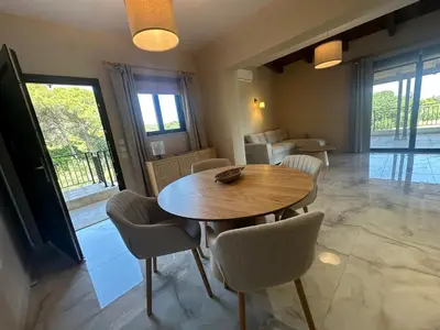 a dining room with a wooden table and chairs at Katalyma Vouno in Ialyssos