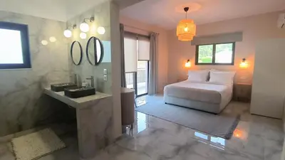a bedroom with a bed and a sink and mirror at Katalyma Vouno in Ialyssos