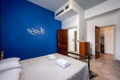 a blue bedroom with a bed with two towels on it at Diamanti Villa Prime Location in Rhodes Town