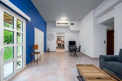a living room with a blue wall and a couch at Diamanti Villa Prime Location in Rhodes Town