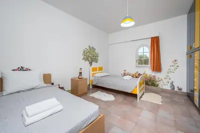a bedroom with two beds and a window at Diamanti Villa Prime Location in Rhodes Town