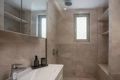 a bathroom with a shower and a sink and a mirror at Casadi City Apartment in Rhodes Town