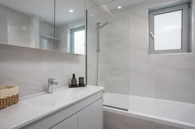 a white bathroom with a shower and a sink at Casadi City Apartment in Rhodes Town