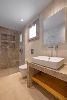 a bathroom with a tub and a toilet and a sink at Arfna Villas in Afantou