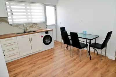 a kitchen with a table and chairs and a washing machine at Dionysus Apartment in Rhodes Town