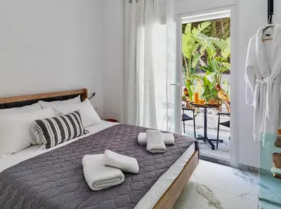 a bedroom with a bed with two towels on it at Sunny Nest Apartments in Ixia