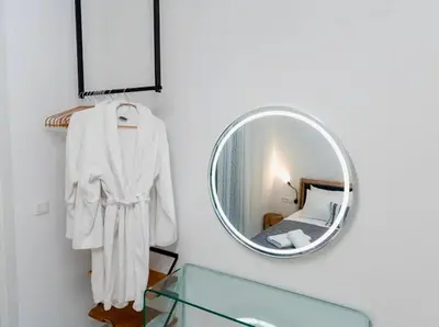 a mirror hanging on a wall next to a bedroom at Sunny Nest Apartments in Ixia