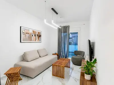 a living room with a couch and a chair at Sunny Nest Apartments in Ixia
