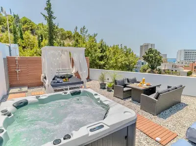 a hot tub on the roof of a building at Sunny Nest Apartments in Ixia