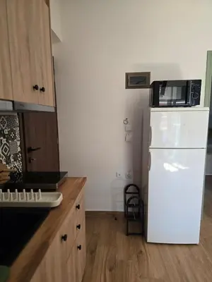 a kitchen with a white refrigerator and a microwave at The cozy nest in Rhodes in Rhodes Town