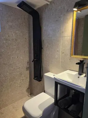 a bathroom with a toilet and a sink and a mirror at The cozy nest in Rhodes in Rhodes Town