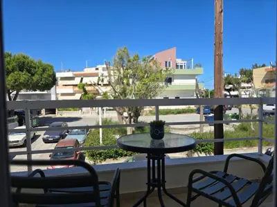 a table on a balcony with a view of a street at The cozy nest in Rhodes in Rhodes Town