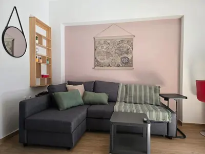 a living room with a gray couch and a table at The cozy nest in Rhodes in Rhodes Town