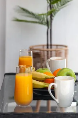 a tray with two cups of orange juice and fruit at Casa Aurora Rhodes in Rhodes Town