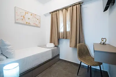 a bedroom with a bed and a desk and a chair at Haraki Bliss in Haraki