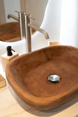 a wooden bathroom sink with a metal faucet at Haraki Bliss in Haraki