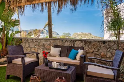 a patio with chairs and a couch and a table at Haraki Bliss in Haraki