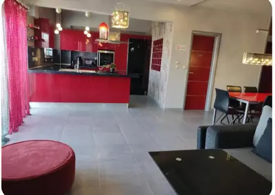 a living room with red cabinets and a kitchen at Rhodos City in Rhodes Town