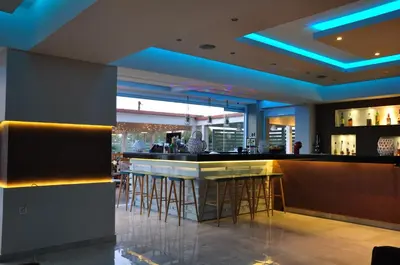 a bar in a restaurant with blue lighting at Sea Melody Beach Hotel Apartments in Ialyssos