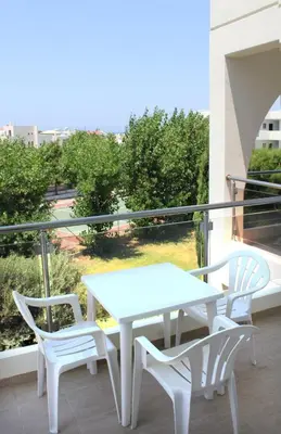 a white table and chairs on a balcony at Sea Melody Beach Hotel Apartments in Ialyssos