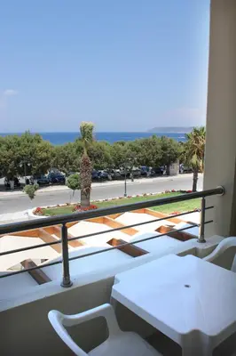 a balcony with chairs and a view of a street at Sea Melody Beach Hotel Apartments in Ialyssos