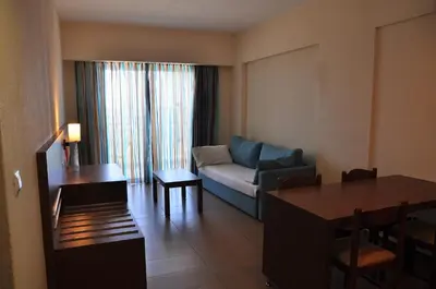 a living room with a couch and a table at Sea Melody Beach Hotel Apartments in Ialyssos