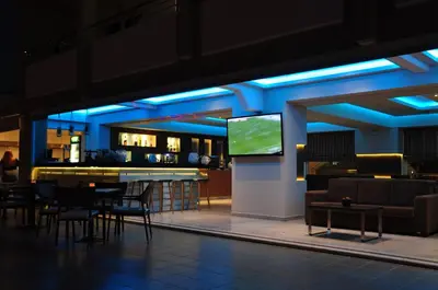 a lobby with a bar and a tv in a building at Sea Melody Beach Hotel Apartments in Ialyssos
