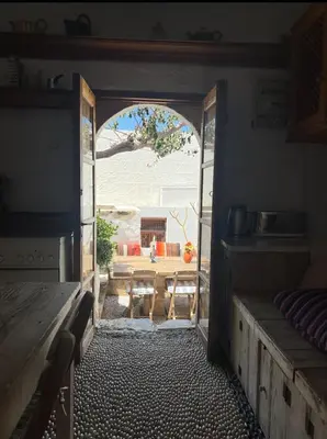 an open door to a patio with a table and a table at Villa Kali in Líndos