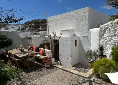 a white house with a table and a dining room at Villa Kali in Líndos