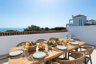 a wooden table with food on top of a balcony at Paradiso Luxury Beachfront Villa in Gennadi