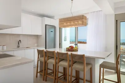 a kitchen with a table with chairs and a window at Paradiso Luxury Beachfront Villa in Gennadi