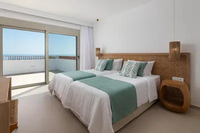 a bedroom with a large bed and a large window at Paradiso Luxury Beachfront Villa in Gennadi
