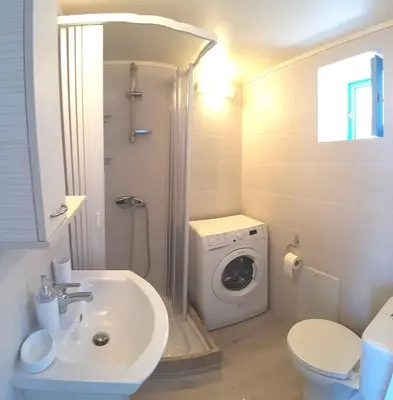 a bathroom with a sink and a washing machine at Villa Panorama in Halki