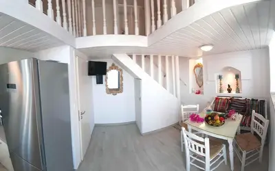 a kitchen and dining room with a table and a refrigerator at Villa Panorama in Halki