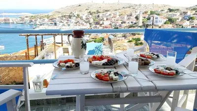 a table with plates of food on a balcony at Villa Panorama in Halki