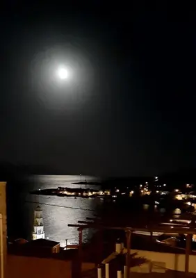 a full moon rising over the water at night at Villa Panorama in Halki