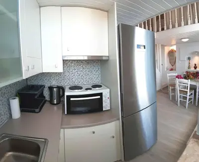 a kitchen with a stainless steel refrigerator and white cabinets at Villa Panorama in Halki