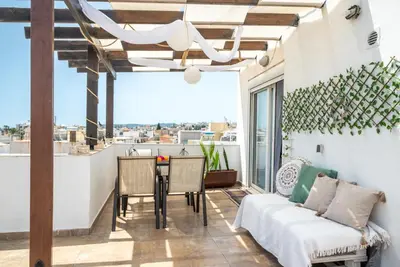 a patio with a couch and a table on a balcony at Luna Loft in Rhodes Town