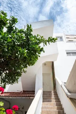 a stairway leading up to a white building with pink flowers at Luna Loft in Rhodes Town