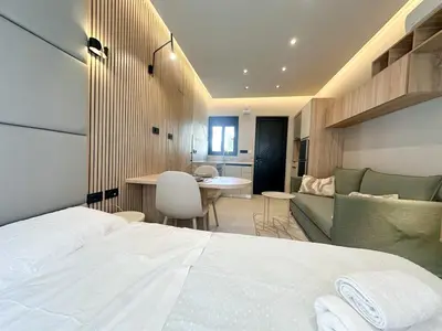 a bedroom with a bed and a living room at Anna Tiny Apartments in Rhodes Town