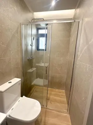 a bathroom with a toilet and a glass shower at Anna Tiny Apartments in Rhodes Town