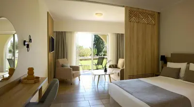 a bedroom with a bed and a living room at Kiotari Miraluna Beach Resort in Kiotari