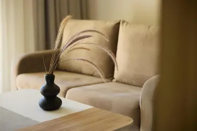 a living room with a couch and a vase on a table at Kiotari Miraluna Beach Resort in Kiotari