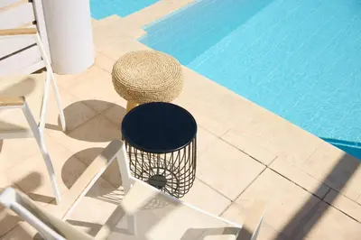 a chair with a hat sitting next to a swimming pool at Kiotari Miraluna Beach Resort in Kiotari