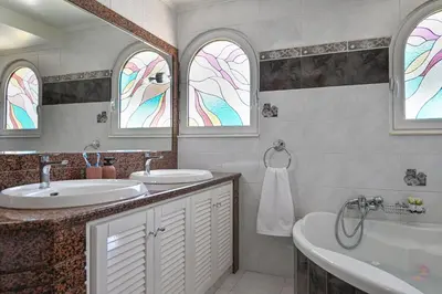 a bathroom with two sinks and a tub and two windows at Maio Seaview & Sunset Stay in Kremasti Rhodes in Kremasti