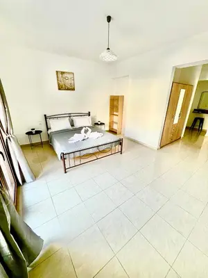 a bedroom with a bed and a tiled floor at KIDONIA luxury villa in Archangelos