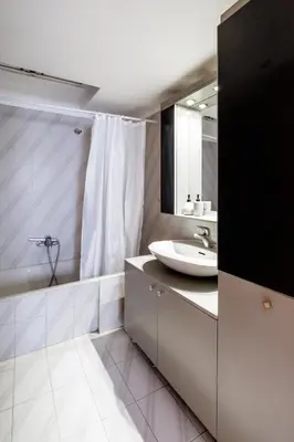 a white bathroom with a sink and a mirror at Marys House 2 in Rhodes Town